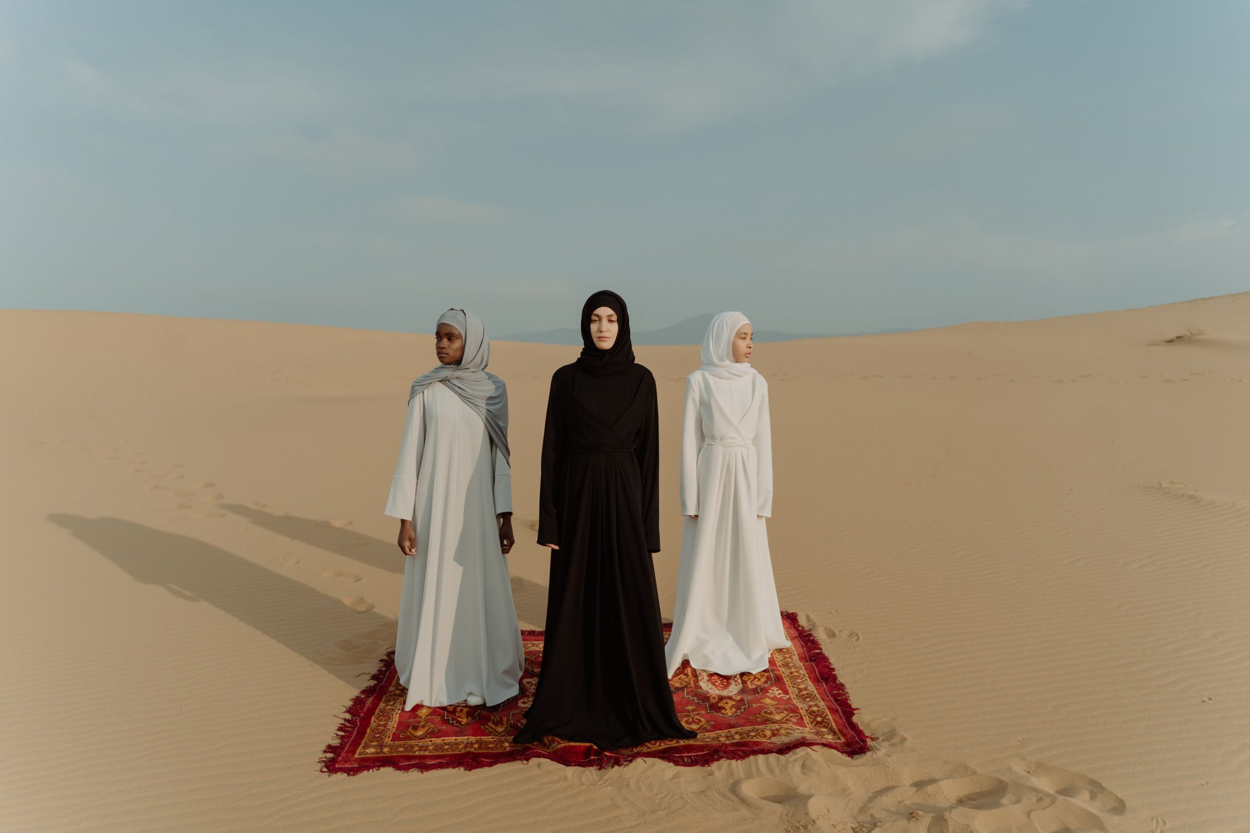 Trois femmes en robes traditionnelles dans le désert