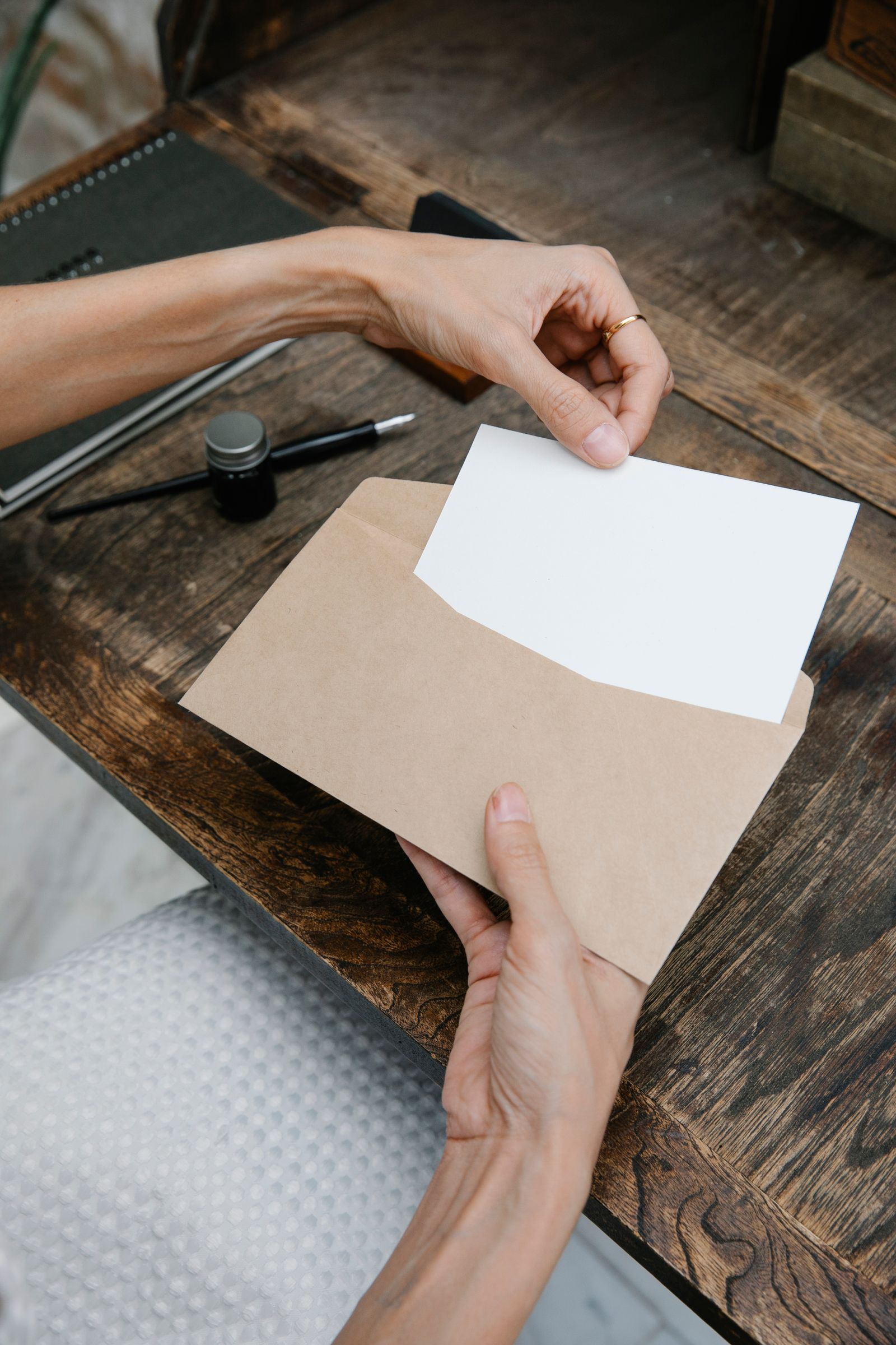 Mains qui ouvrent une enveloppe en papier kraft