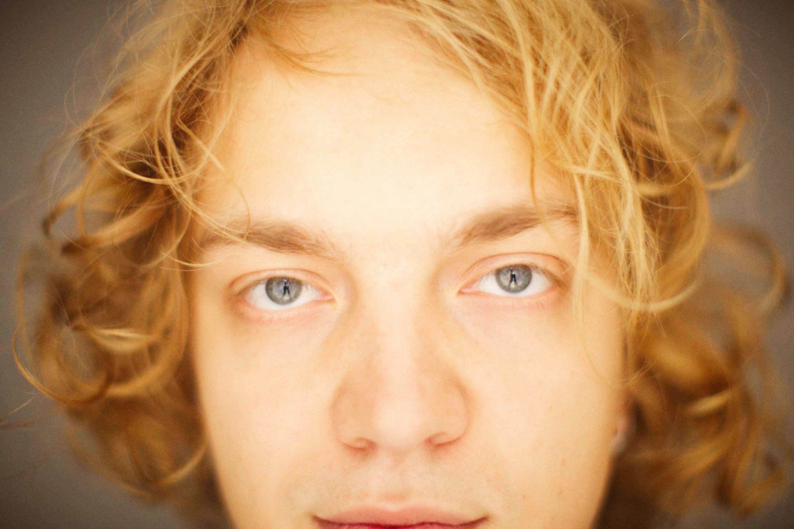 Portrait gros plan femme cheveux blonds boucles yeux bleus