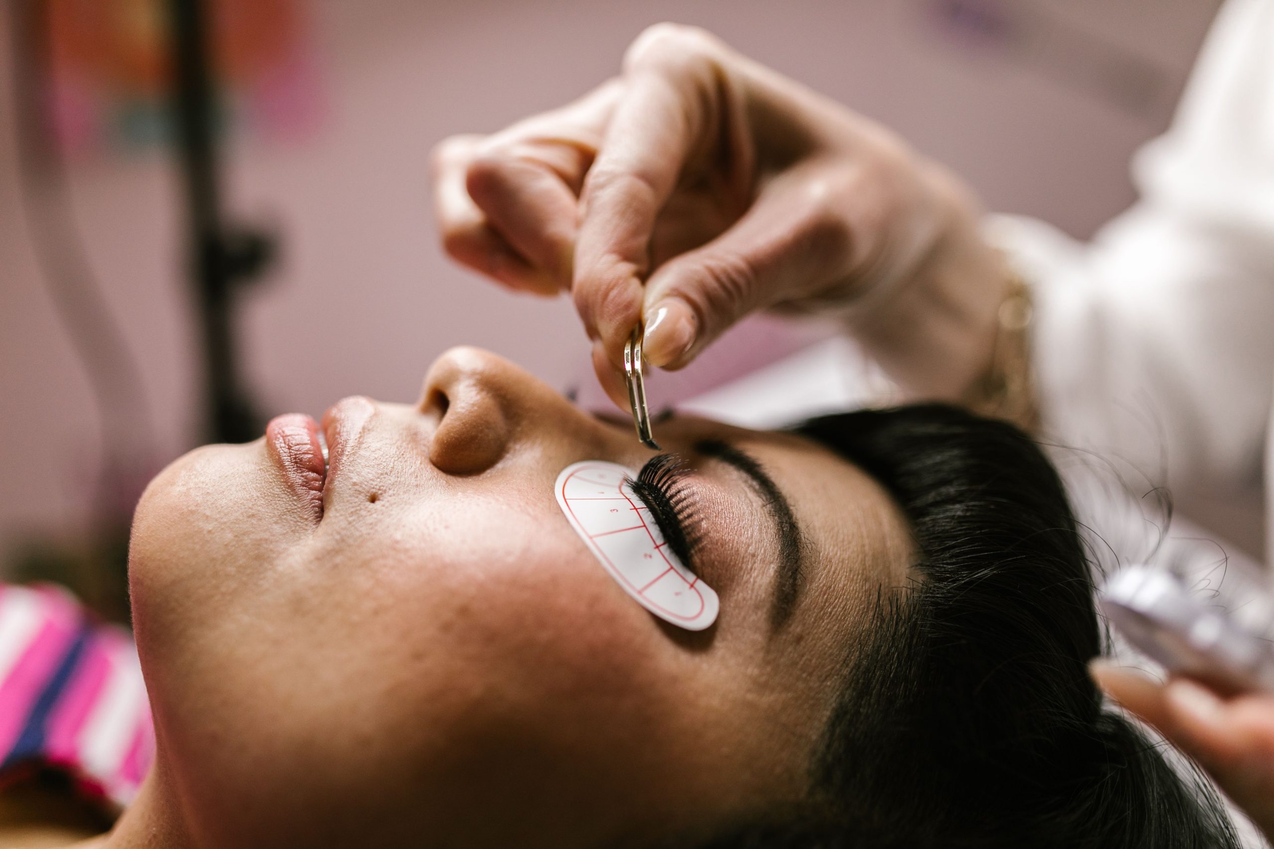 Femme recevant une extension de cils en salon