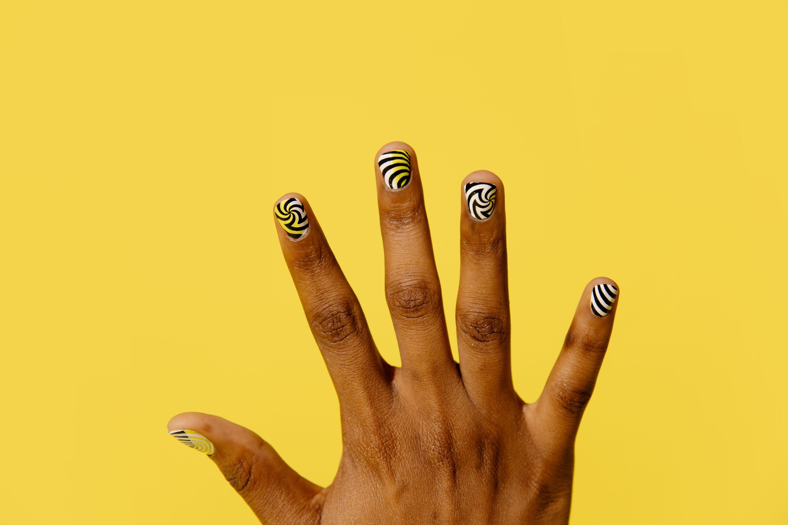 Nail art à motifs sur fond jaune vif